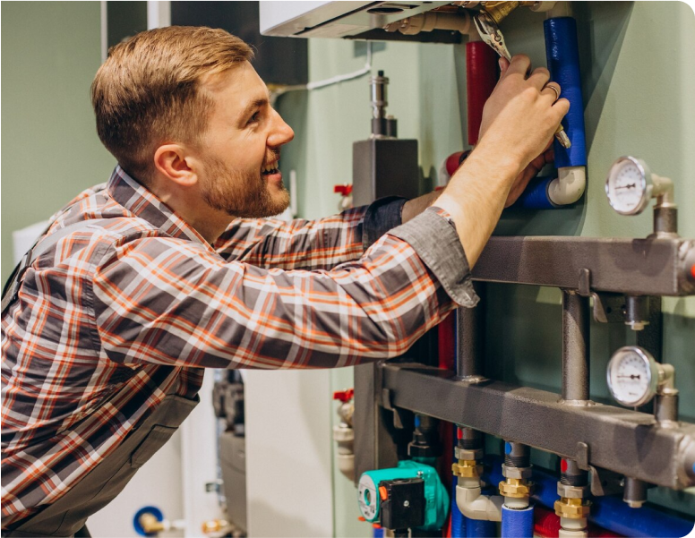 Man working on plumbing pipes and gauges.